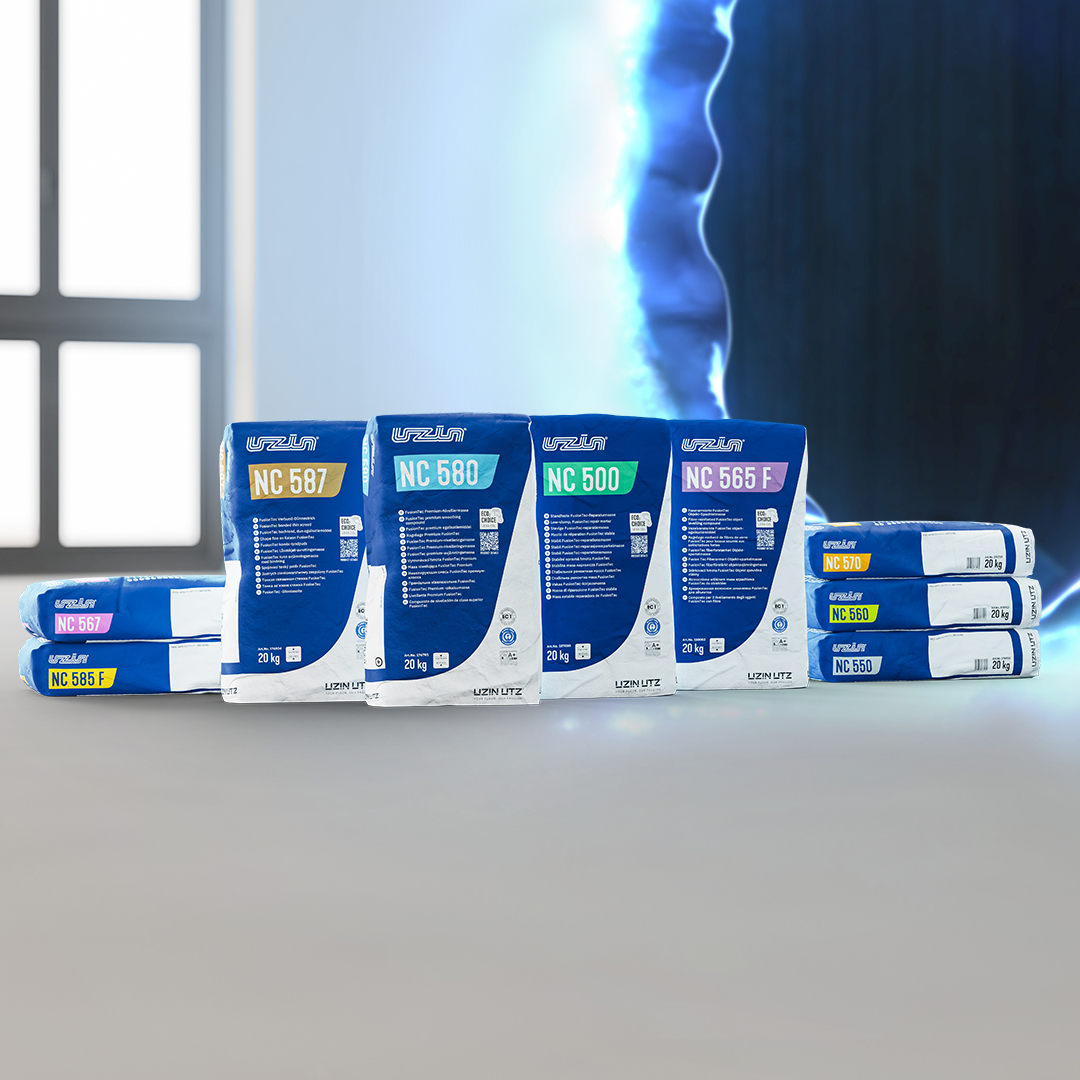 Mehrere aufrecht stehende und gestapelte Säcke mit Baumaterialien, die mit Litokol- und NC-Produktcodes beschriftet sind, stehen auf einem glatten Boden mit einer blau beleuchteten Wand im Hintergrund.