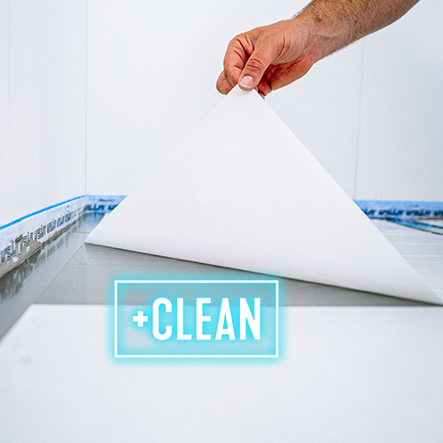 A hand lifts a large white sheet from a tiled surface, revealing a clean area underneath. The word CLEAN in bold letters and a blue box is displayed in the foreground.