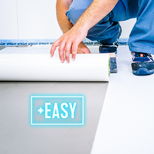 A person kneels on the floor, unrolling a large sheet of white material. The word +EASY is highlighted in blue in the foreground, suggesting the task is simple to do.